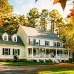 Two-story house with porch and windows, surrounded by trees, reflecting a family-owned plumbing business's inviting charm.