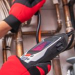 Professional plumber using gas leak detection equipment on pipes, highlighting safety measures for gas line integrity in homes.